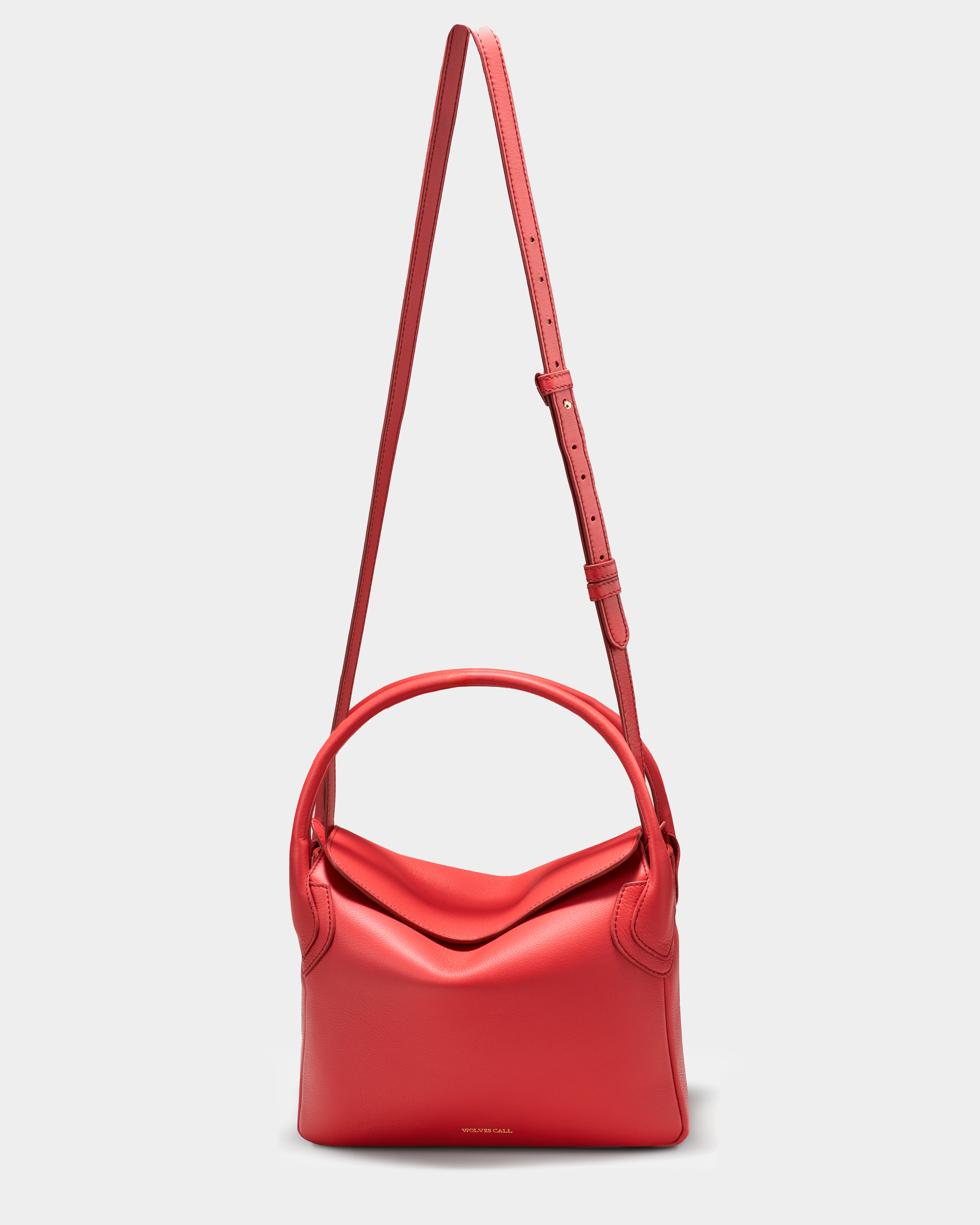 Wolves Call 'The Maria' red handbag with the adjustable crossbody strap extended — final campaign image