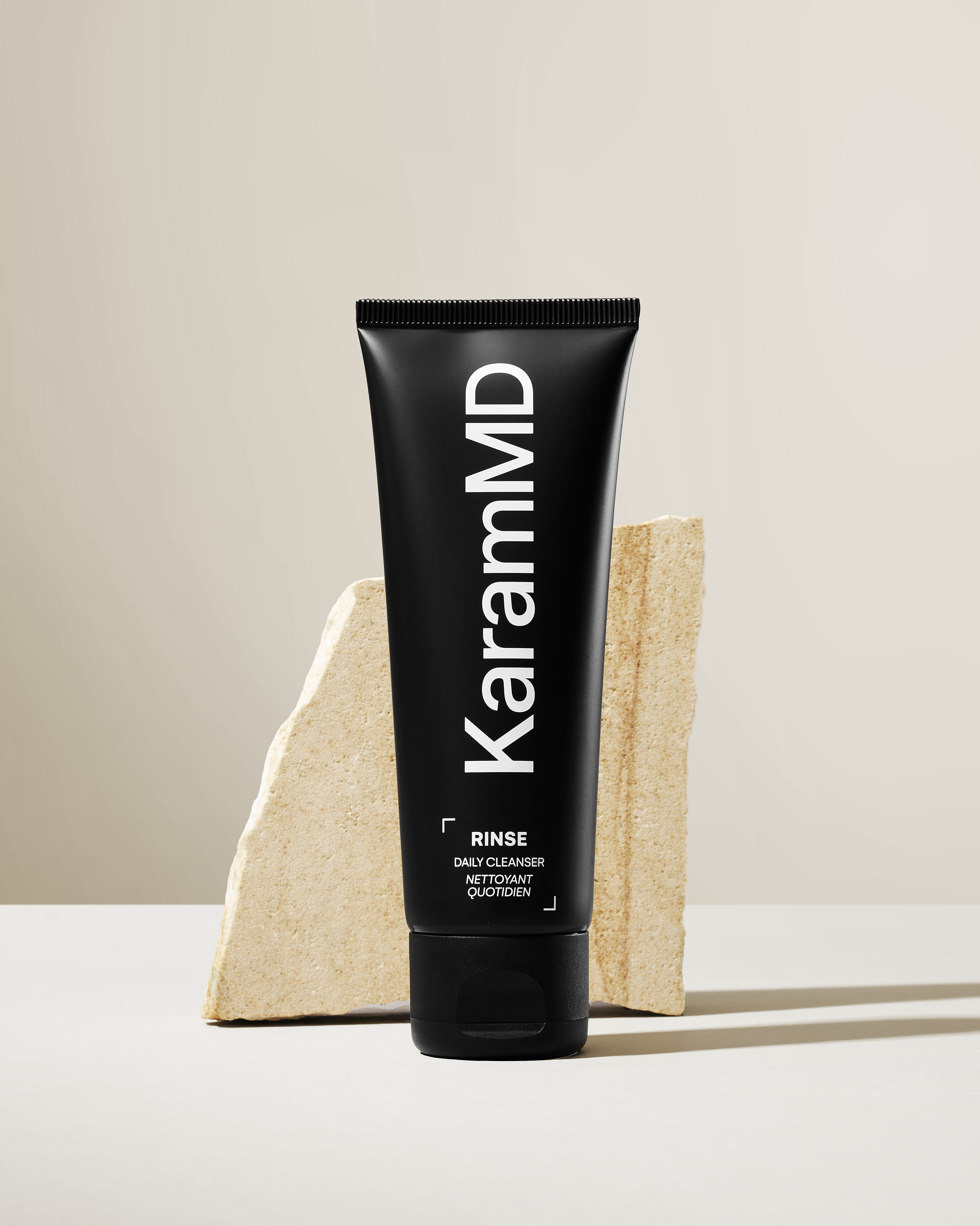 KaramMD Rinse Daily Cleanser tube on a stone plinth