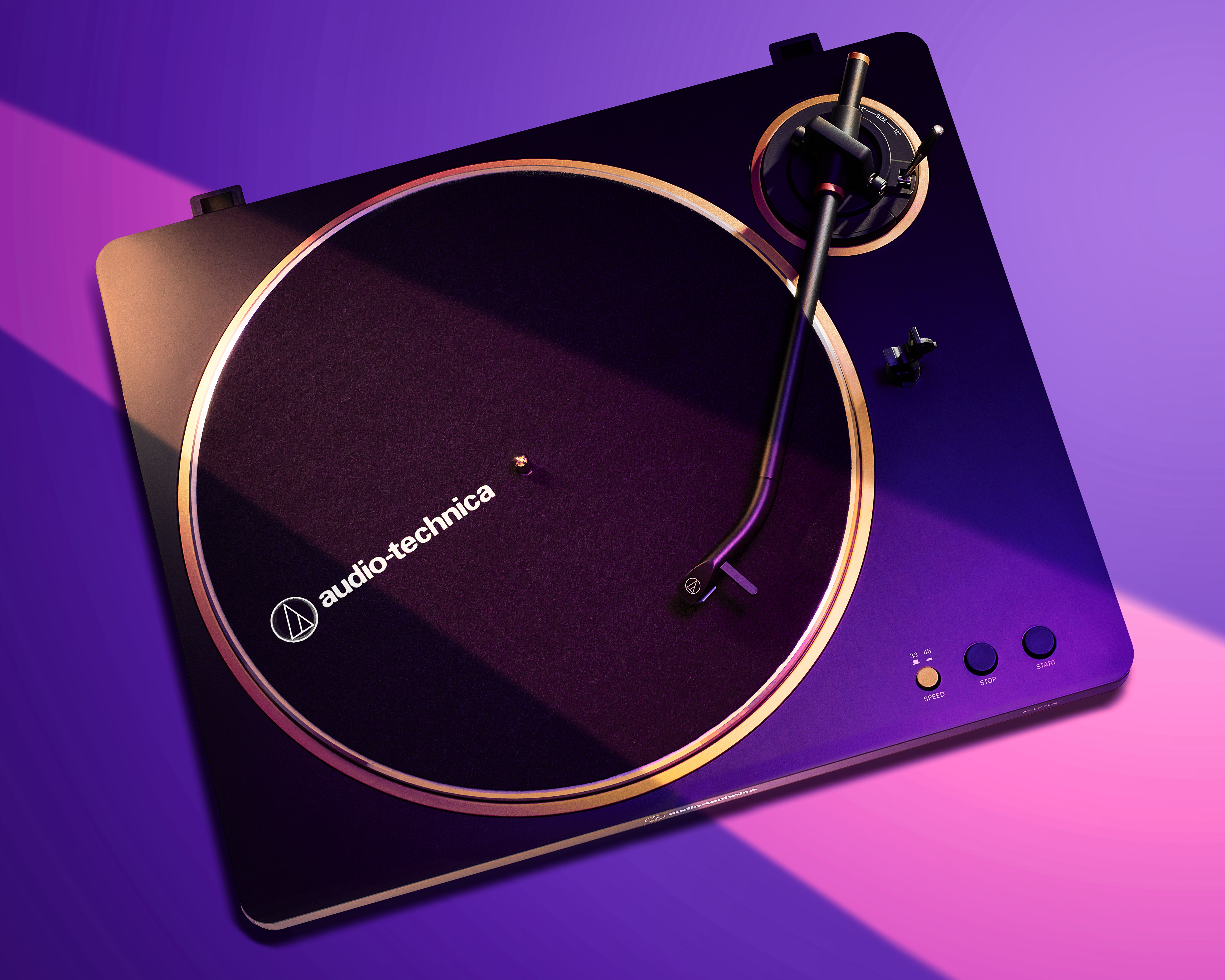 Overhead campaign shot of an Audio-Technica turntable lit with purple and pink gels