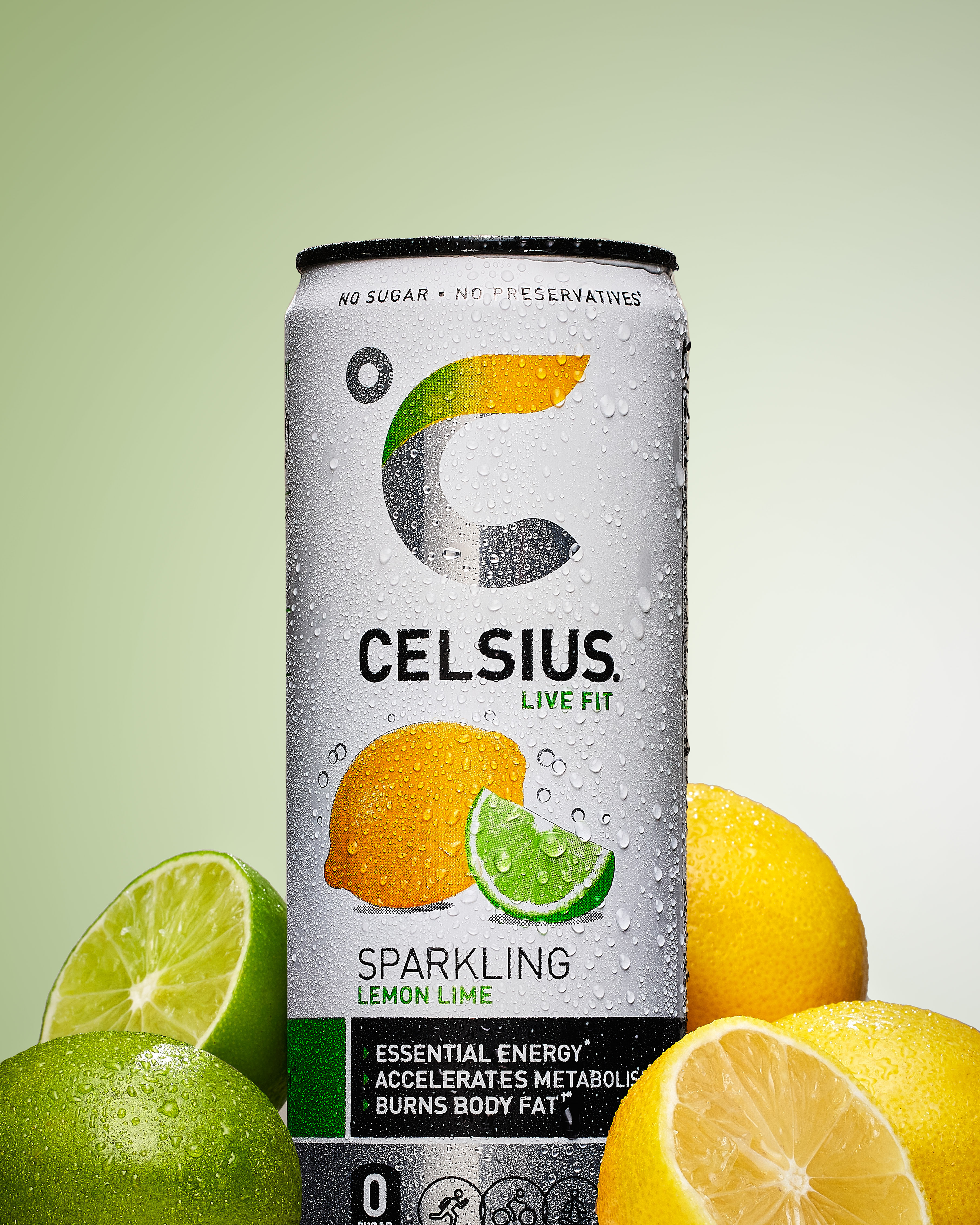 Celsius Sparkling Lemon Lime can styled with fresh lemons and limes on a green gradient backdrop